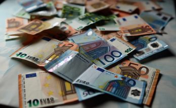 Des billets de banque en euros éparpillés sur une table.